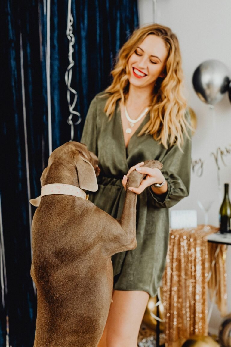 Joyful indoor party with a woman and her dog having fun together.