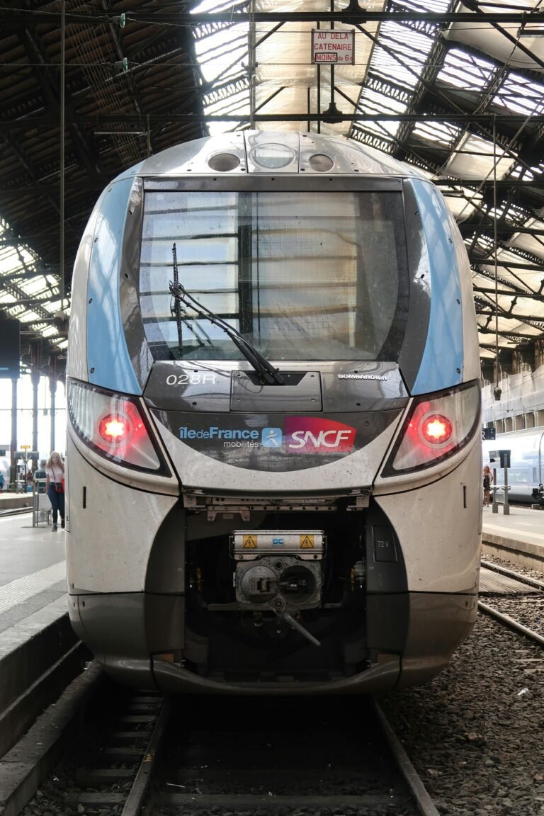 Front view of SNCF train at urban railway station under daylight.