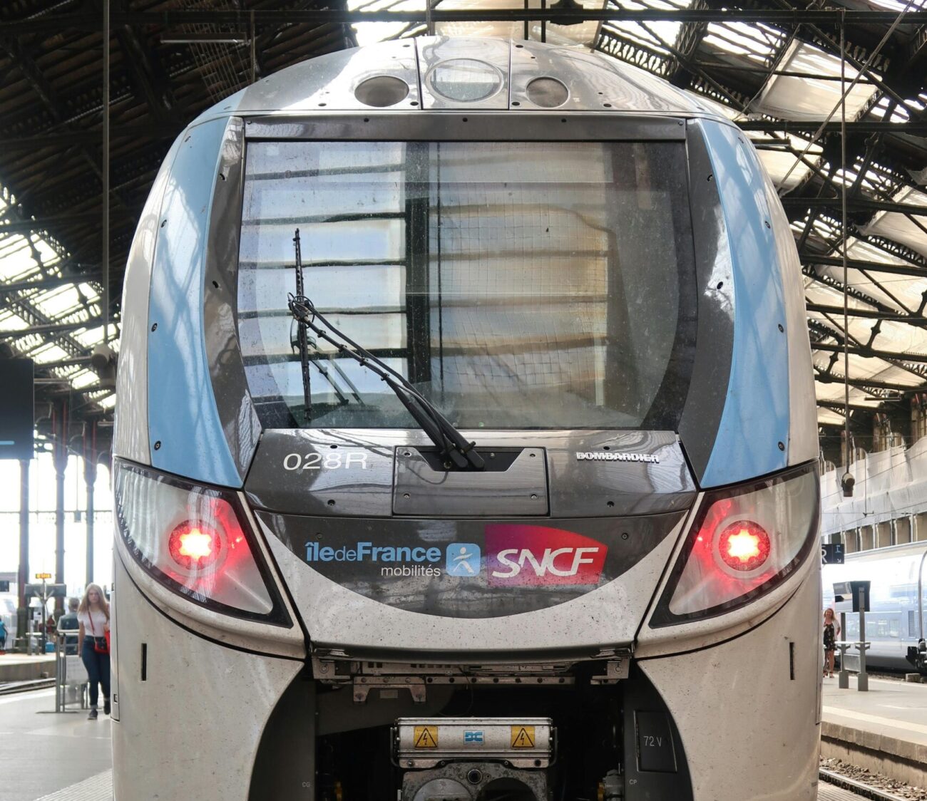 Front view of SNCF train at urban railway station under daylight.